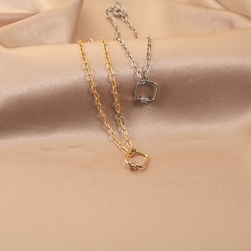 Minimalist gold and silver link chain necklaces with square carabiner-style pendant charms on a silk background.