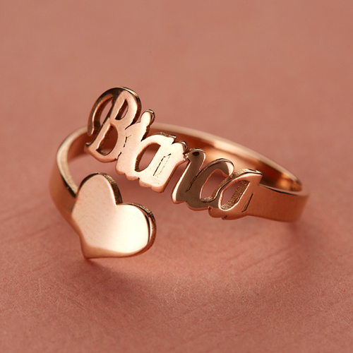 Custom rose gold open-wrap fashion ring featuring a personalized script name and a polished heart accent.
